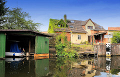 Pegelanzeige der lichten Durchfahrtshöhe einer Brücke in Grabow - Bootshaus am Kanal, Wohnhaus mit Efeu bewachsen.