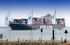 Fahnen mit Stader Logo - Frischer Wind im Norden -  am Stader Sand; 336m lange und knapp 46m breite Containerschiff NYK ORION fährt elbabwärts - der Frachter kann 9040 TEU Container transportieren.