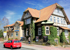 Architektur in Uelzen - Wohnhaus mit Efeu bewachsen - SPD Haus, rotes Auto; dahinter das Gebäude der Polizei.