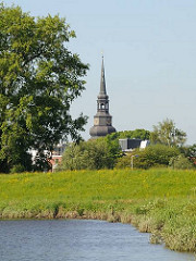 Blick über die Wiesen am Ufer der Schwinge zum Kirchturm der Kirche Kirche Ss. Cosmae et Damiani in Stade.