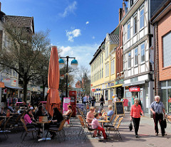 Frühlingstag in der Sonne - Eiscafé mit Tischen in einer Fussgängerzone von Uelzen.