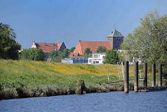 Ufer der Schwinge mit Deich - Dalben am Ufer; Blick zur gotischen Kirche St. Wilhadi in Stade.
