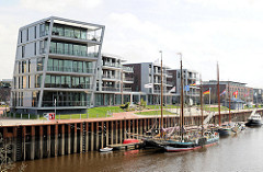 Historische Ewer im Hafen Stades - mehrstöckige Wohnhäuser am Hafen.