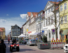 Bilder aus Uelzen - mehrstöckige Geschäftshäuser / Wohnhäuser in der Gudestrasse - en rotes Quad, All Terrain Vehicle auf der Strasse.