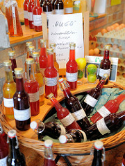 Flaschen mit Holunderblütensirup in einem Korb - Hofladen in Bünningstedt; Gemeinde Ammersbek.