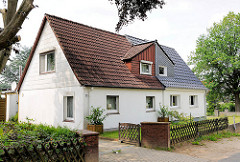 Zweifamilienhaus mit Jägerzaun und Holztor; unterschiedliche Dachpfannen - Siedlung Daheim; Ahrensburg - Ammersbek; Metropolregion Hamburg.