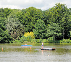 Rantzauer See in Barmstedt - Tretboot und Badende, hohe Bäume am Ufer vom See.