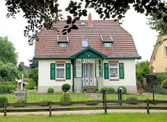 Einzelhaus, Wohnhaus in Hoisbüttel / Ammersbek - Architektur Heimatstil; grüne Fensterläden, Holzläden; kleine Windmühle im Garten.