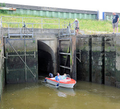 Schleuse zum Rhin / geöffnete Rhinschleuse zum Aussenhafen Glücksstadt; ein Motorboot hat die Schleuse gerade passiert.