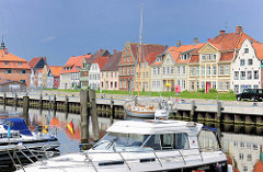 Häuserzeile am Binnenhafen von Glückstadt an der Unterelbe - historische Wohngebäude; Sportboote / Motorboote am Kai.