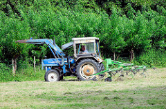 Landwirt mit Traktor beim Wenden von gemähtem Gras auf einer Wiese in Bünningstedt / Ammersbek.