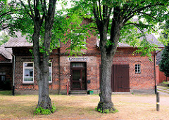 Wohnhaus - Ziegelgebäude, Einfamilienhaus mit Garagentor; über dem Eingang steht die alte Aufschrift GASTWIRTSCHAFT; Fotos aus der Gemeinde Ammersbek / Ortsteil Bünningstedt.