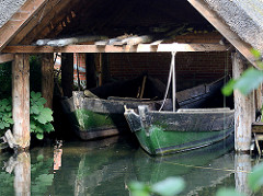 Bootshaus mit Holzboote / Fischerboote am Ufer des Ratzeburger Sees - Hütte mit Reetdach.