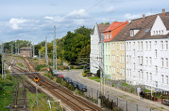 Wohnblocks / Wohnhäuser an der Güterbahnstrecke Wismar - im Hintergrund ein Stellwerkgebäude, beschrankter Bahnübergang.