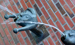 Brunnen Kurpark Mölln; Wasserspeier - Wasser speiende Bronzeköpfe - Kunststil der 1960er Jahre.