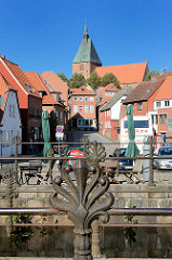 Dekorgeländer Eisen am Mühlengraben in der Stadt Mölln - im Hintergrund der Mühlenplatz und die Altstadt sowie die Möllner St. Nicolai-Kirche.