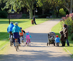 Kurpark Mölln - 2007 unter Denkmalschutz gestellt - 1968 eröffnet, Entwurf Hamburger Gartenarchitekt Gustav Lüttge. Familie mit Fahrrad - Kinderfahrrad; Spaziergänger mit Kindern und Kinderkarre.