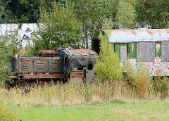 Ehem. Rangiergleis an der Bahnstrecke am Platter Kamp in Wismar - rostige Lokomotive, Bahnwaggon.