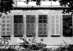 Villa / Abrisshaus in Wismar - Fenster mit Metallplatten verschlossen; Schwarz-Weiss Fotografie.
