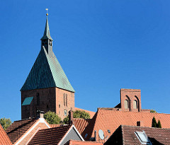 Kirchturm der Möllner St. Nicolai-Kirche über den Dächern der Altstadt; re. der Giebel des Möllner Rathauses.