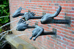 Brunnen Kurpark Mölln; Wasserspeier - Wasser speiende Bronzeköpfe - Kunststil der 1960er Jahre.