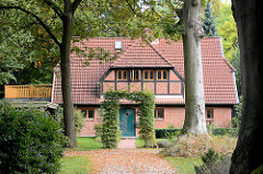 Architektur in der Gemeinde Großhansdorf - neuerbautes Fachwerkhaus mit Ziegelfüllung; hohe Bäume