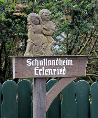 Geschnitztes Holzschild - Hinweisschild, Junge / Mädchen - Schullandheim Erlenried in Grosshansdorf.