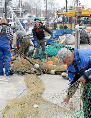 Fischereihafen an der Ostsee in Łeba, Polen - Fischer arbeiten an den Netzen.