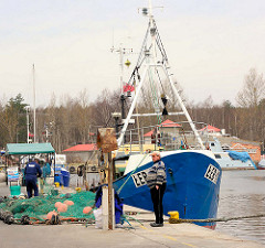 Fischereihafen an der Ostsee in Łeba, Polen - Netze liegen am Kai; Fischer + Fischkutter.