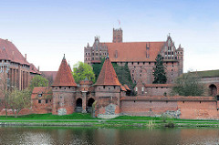 Blick über den Fluss Nogat zur Burganlage Malbork / Marienburg - historische Ordensburg, Backsteinarchitektur.