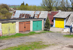 Garagen mit farbigen Holztoren - Haus mit Wellblechdach + Garageneinfahrt; Bilder aus Trzebiatow / Treptow an der Rega.