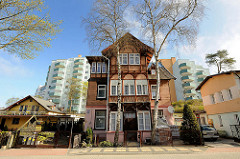 Alte Wohnhäuser, historischer Baustil - moderne Wohnblocks mit farbigen Balkonbrüstungen in Międzyzdroje / Misdroy (Polen); alt + neu.