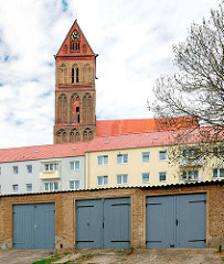 Wohnhäuser und Garagentore in Anklam - Kirchturm der Marienkirche aus dem 13. Jahrhundert.