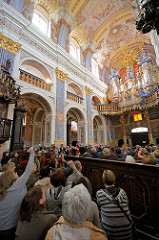 Kircheninneres der barocken Kirche Święta Lipka, Heiligelinde - Polen. Kirchenbesucher auf Kirchenbänken - Deckengemälde, Orgel erbaut 1721 von Johann Josua Mosengel.