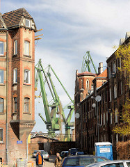 Historische Architektur - Arbeiterwohnungen, Etagenwohnungen - im Hintergrund Kräne der Danziger Werft - stocznia Gdańsk.