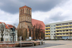 Marktplatz der Hansestadt Anklam - Brunnen und moderne Neubauten - Nikolaikirche zwischen Wohnhäusern; die dreischiffige Hallenkirche der Backsteingotik stammt aus dem 14. Jahrundert.