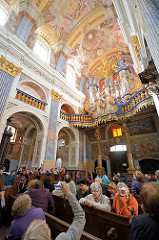 Kircheninneres der barocken Kirche Święta Lipka, Heiligelinde - Polen. Kirchenbesucher auf Kirchenbänken - Deckengemälde, Orgel erbaut 1721 von Johann Josua Mosengel.