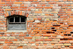 Alte Ziegelmauer mit Fenster - die Mauersteine sind teilweise ausgehöhlt, zerfressen - Architekturbilder aus Anklam.