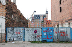 Wand mit Graffiti - Ziegelmauer, Speicherinsel Danzig - im Hintergrund historische Architektur der Danziger Altstadt.
