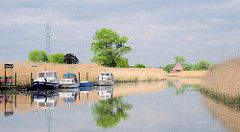 Fluss ESTE bei Buxtehude - Schilf am Ufer des Flusses, der zur Elbe fliesst - Sportboote liegen an einem Schlengel.