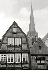 Architektur in Buxtehude, Fachwerkhaus, Kirchturm der St. Petri Kirche; Schwarz-Weiss Aufnahme.