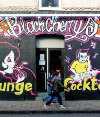 Hausfassade mit Graffiti - Bar; Fussgänger - Bilder aus der Stadt Uetersen, Kreis Pinneberg.