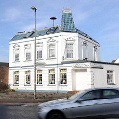 Restgebäude Architektur Historismus - Uetersener Hof, Tornescher Weg in Uetersen, Kreis Pinneberg; weisse Fassade, grüne Dachpfannen - fahrendes Auto.