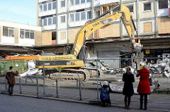 Der Abriss bei den Esso-Häusern hat begonnen - die legendäre Tankestelle auf dem Hamburger Kiez an der Reeperbahn wurde am 12.02.14 abgerissen; ein Bagger räumt die Metallteile in Container. Anwohner beobachten und fotografieren das Ereignis.