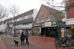 Fussgängerzone im Zentrum von Uetersen - historische Architektur, moderner Neubau - Spaziergänger mit Hund.