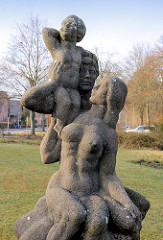 Steinskulptur - Vater, Mutter + Kind auf dem Bahnhofsplatz in Ludwigslust.