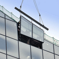 Fassade der Hamburger Elbphilharmonie wird geschlossen - ein Kran passt das Fensterelement in die Fassade ein.