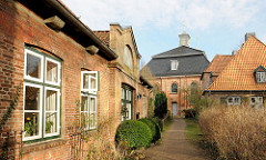 Historische Backsteingebäude und Klosterkirche beim Klosterhof in Uetersen, Kreis Pinneberg; im Vordergrund das Kutscherhaus.