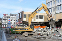 Der Abriss bei den Esso-Häusern hat begonnen - die legendäre Tankestelle auf dem Hamburger Kiez an der Reeperbahn wurde am 12.02.14 abgerissen; ein Bagger räumt die Metallteile in Container.
