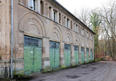 Nebengebäude beim Marstall von Ludwigslust - denkmalgeschützte Architektur; Garagen mit Holztoren.